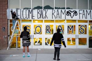 (Trent Nelson  |  The Salt Lake Tribune) Jane Erickson hangs a welcome back banner with help from Lavell and Olivia Manavahe as students return to Highland High School in Salt Lake City on Monday, Feb. 8, 2021.