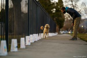 (Trent Nelson  |  The Salt Lake Tribune) Tim Campbell and his dog, Oso, look at the 500 luminarias put out by students and teachers at the McGillis School in Salt Lake City, on Wednesday, March 17, 2021. The luminarias each have a message of gratitude and hope or a reflection on the past year's pandemic