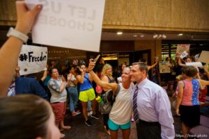 (Trent Nelson  |  The Salt Lake Tribune) Anti-mask mandate crowd celebrates after the Salt Lake County Council voted down Dr. Angela Dunn's mask ordinance for K-6 students, on Thursday, Aug. 12, 2021. Steve DeBry, Chair of the council, interacts.