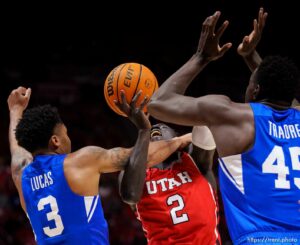 (Trent Nelson  |  The Salt Lake Tribune) Brigham Young Cougars guard Te'Jon Lucas (3) fouls Utah Utes guard Both Gach (2) as the Utah Utes host BYU, NCAA basketball in Salt Lake City on Saturday, Nov. 27, 2021.