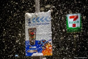 (Trent Nelson  |  The Salt Lake Tribune) Snow falls on a sign advertising iced coffee on Salt Lake City on Saturday, March 5, 2022.