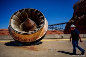 (Trent Nelson  |  The Salt Lake Tribune) A large turbine on display at Glen Canyon Dam in Page, Ariz., on Tuesday, May 20, 2025. Field Division Manager Gus Levy at right.