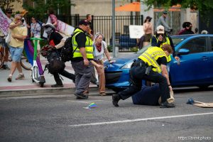 (Trent Nelson | The Salt Lake Tribune) A man lays injured on the street as police respond to a reported shooting during a protest march in Salt Lake City, Saturday, June 14, 2025.
