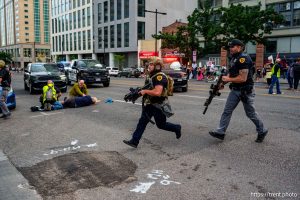 (Trent Nelson | The Salt Lake Tribune) A man lays injured on the street as police respond to a reported shooting during a protest march in Salt Lake City, Saturday, June 14, 2025.