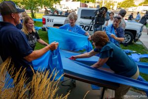 (Trent Nelson  |  The Salt Lake Tribune) People prepare blue ribbons in Tremonton on Tuesday, Aug. 19, 2025 to honor two city police officers who were killed and a sheriffÕs deputy who was wounded two days earlier in a shooting.