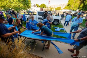 (Trent Nelson  |  The Salt Lake Tribune) People prepare blue ribbons in Tremonton on Tuesday, Aug. 19, 2025 to honor two city police officers who were killed and a sheriffÕs deputy who was wounded two days earlier in a shooting.